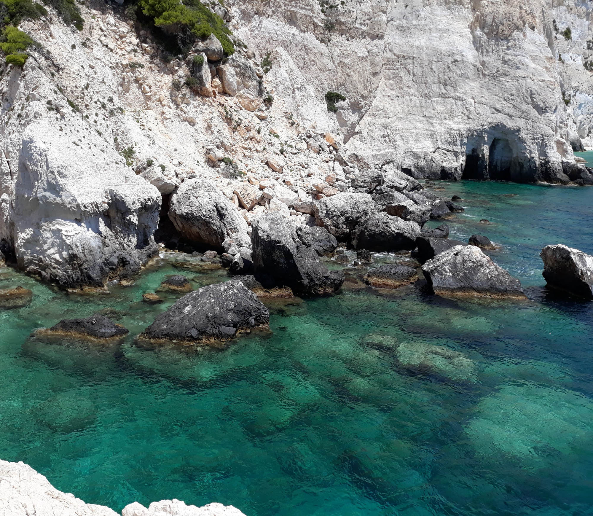Turkusowe morze kontrastuje z bielą wapiennych skał w Plakaki