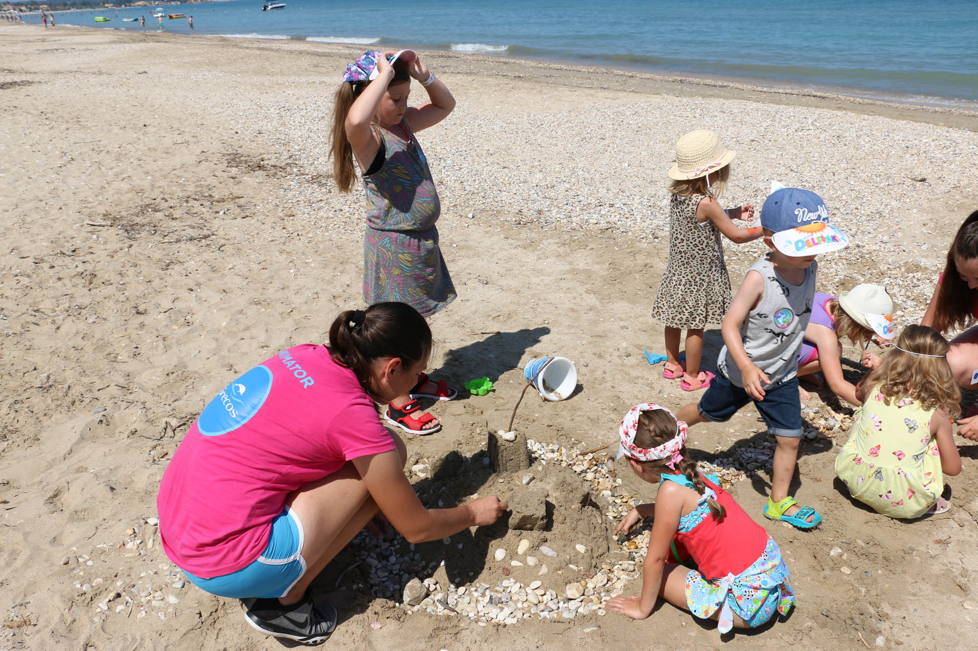 Animatorka klubu delfinki Grecosa bawi się z dziećmi na plaży