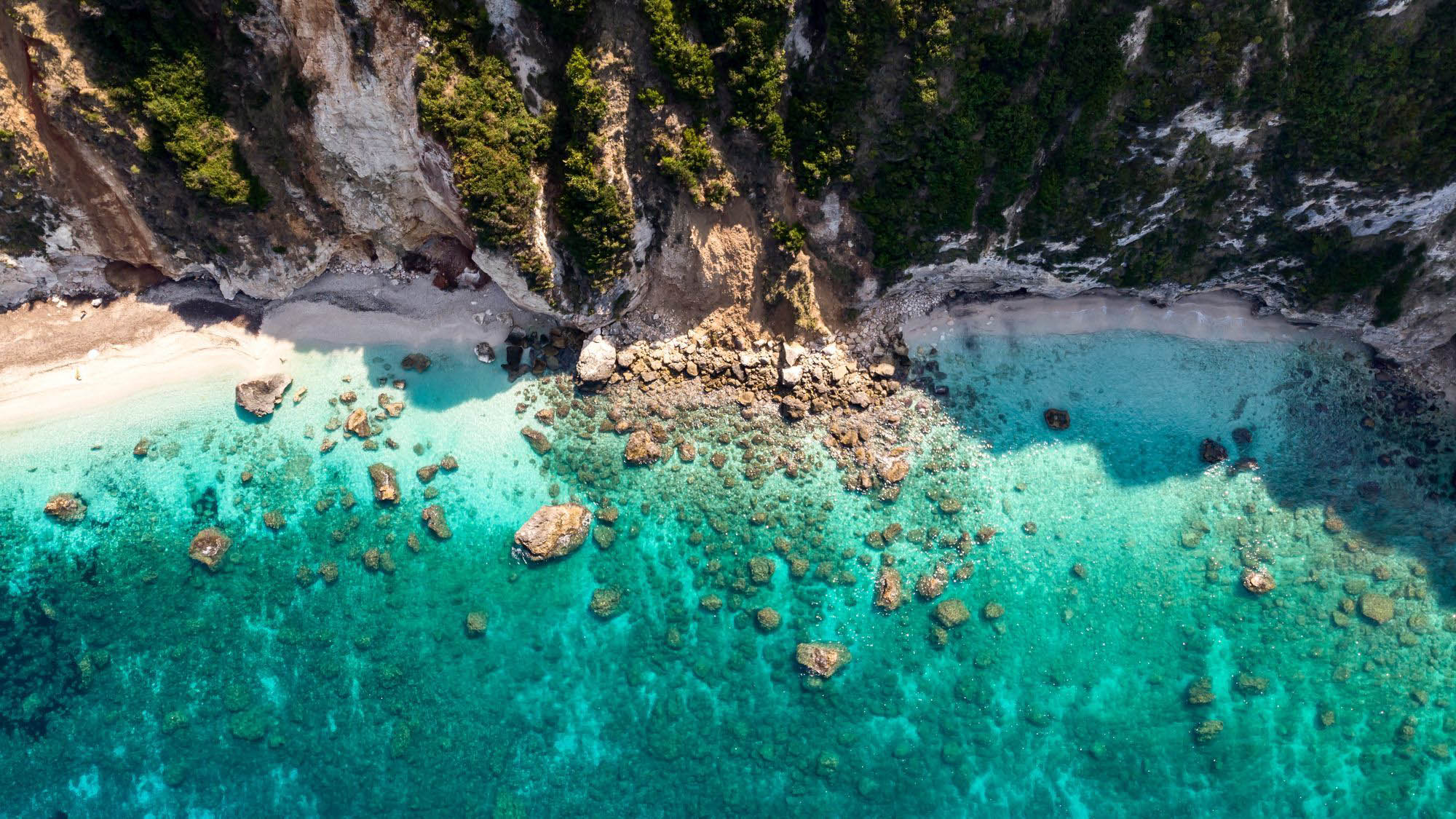 widok na plażę z lotu ptaka, turkusowe morze wśród skał, urocza zatoka