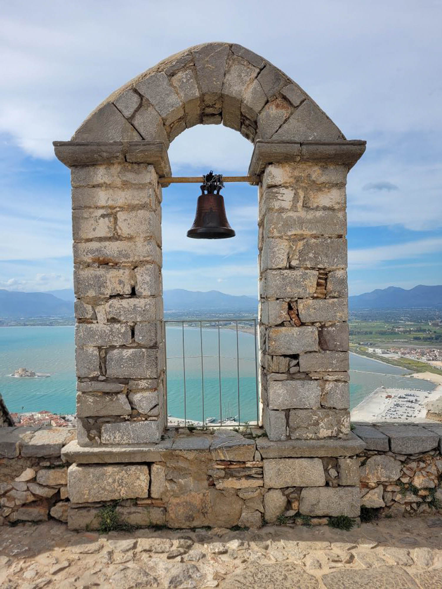 widok na stare budowle ruiny, stara dzwonnica, a za nią widok na morze i niebieskie niebo