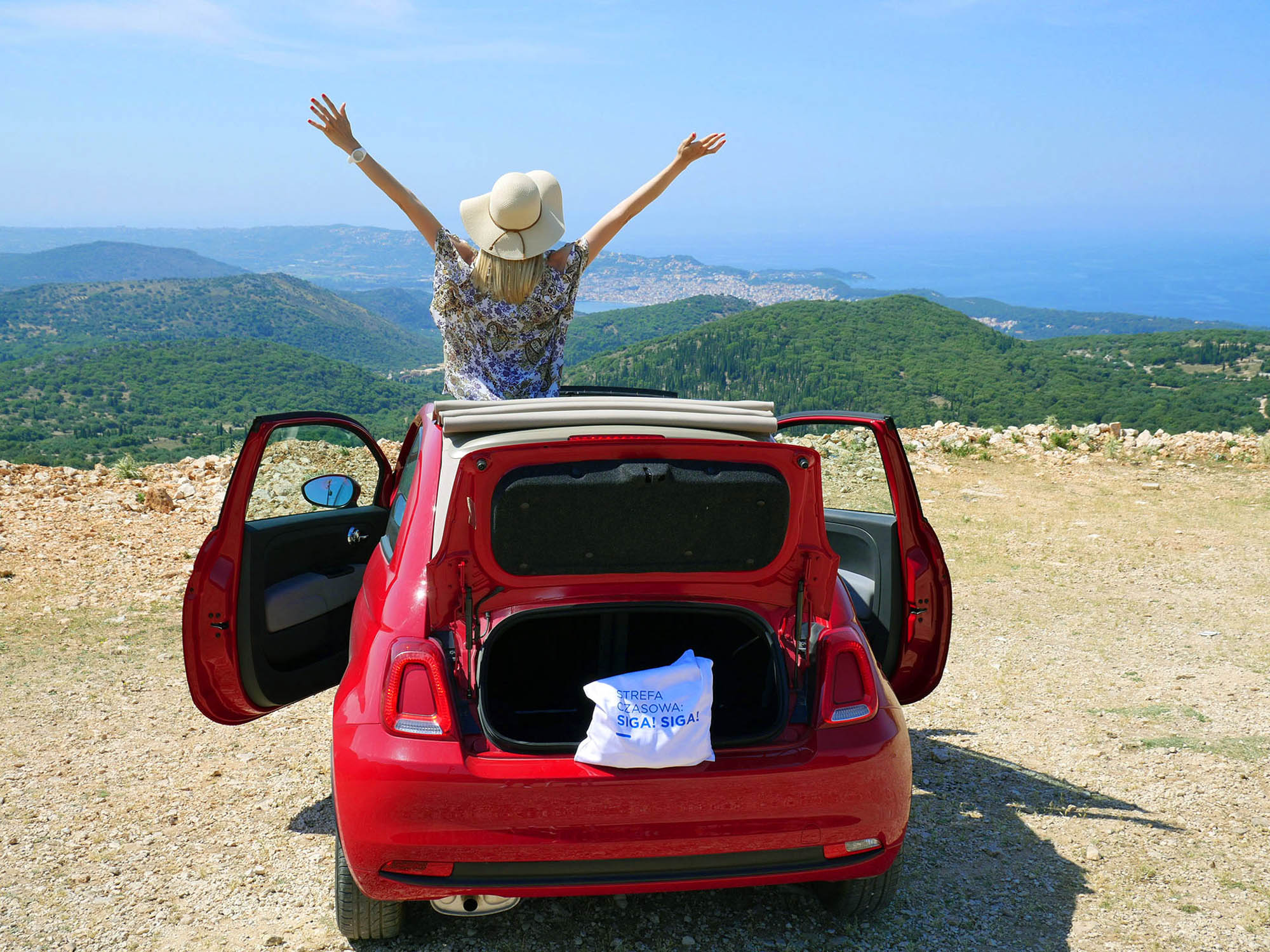 osoba w samochodzie na wycieczce w Grecji, patrzy na piękną, grecką panoramę ze wzgórza