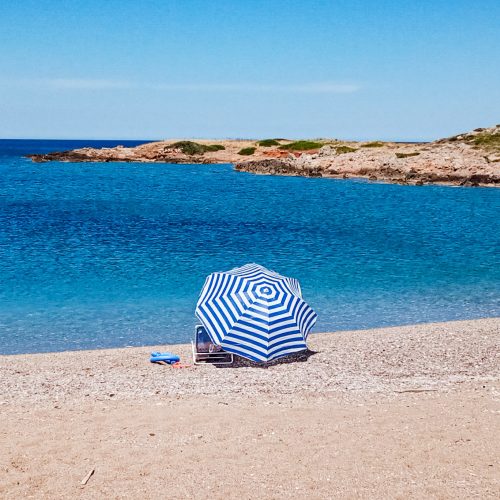 piaszczysta plaża, parasolka na plaży, niebo i niebieskie morze