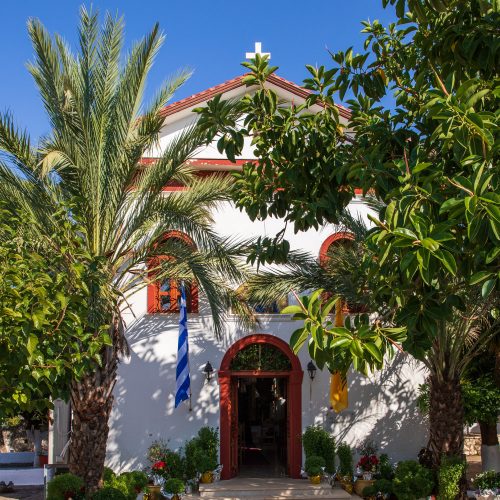grecka cerkiew wśród palm, a nad nią błękitne niebo