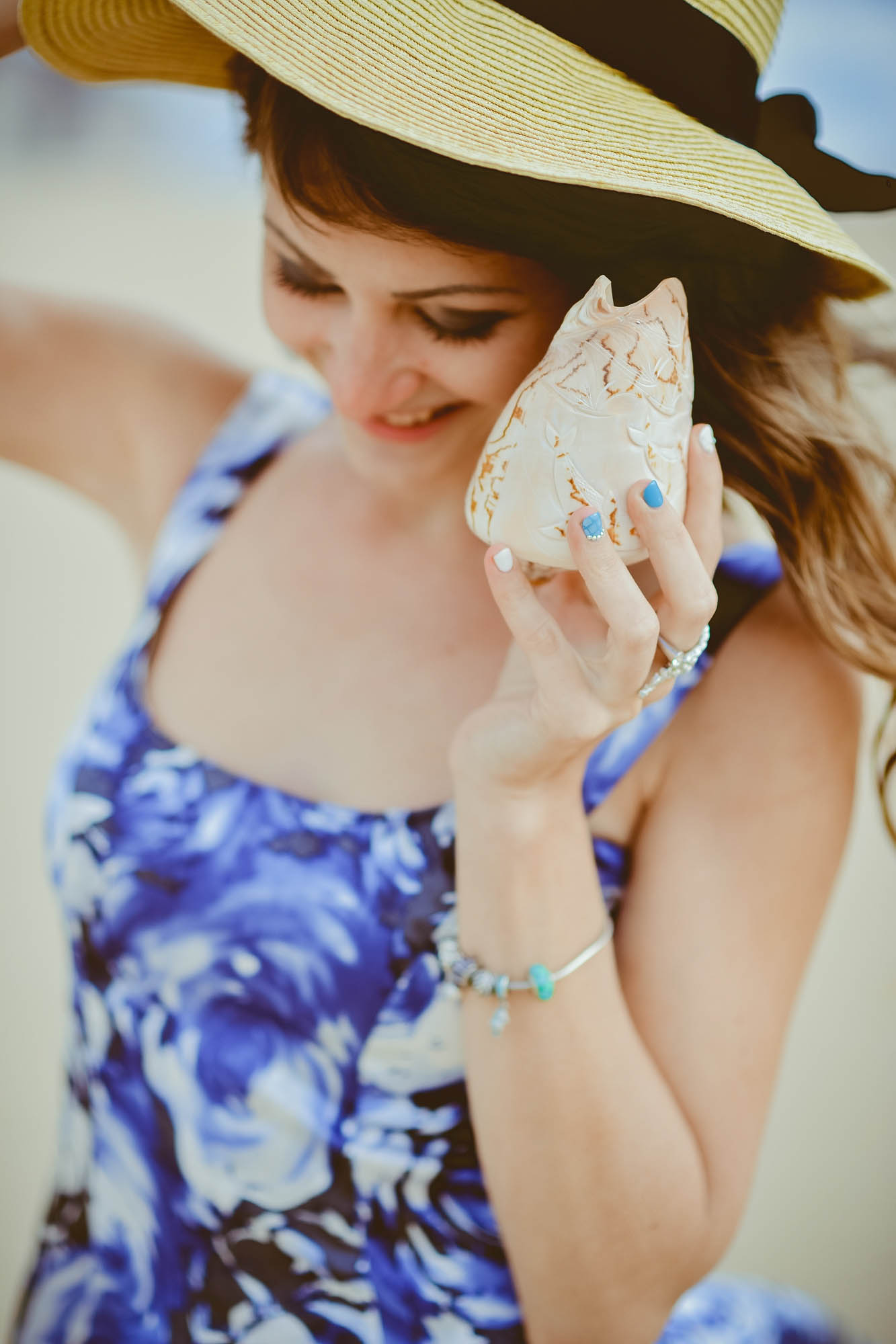 dziewczyna w kapeluszu trzyma muszę, wakacje i morze, szum w muszli