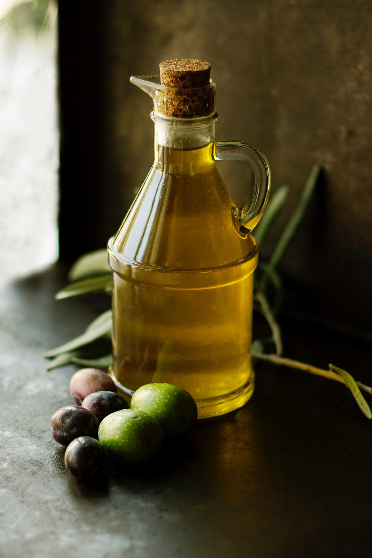 grecka oliwa z oliwkami w przejrzystej butelce, świeżo tłoczona