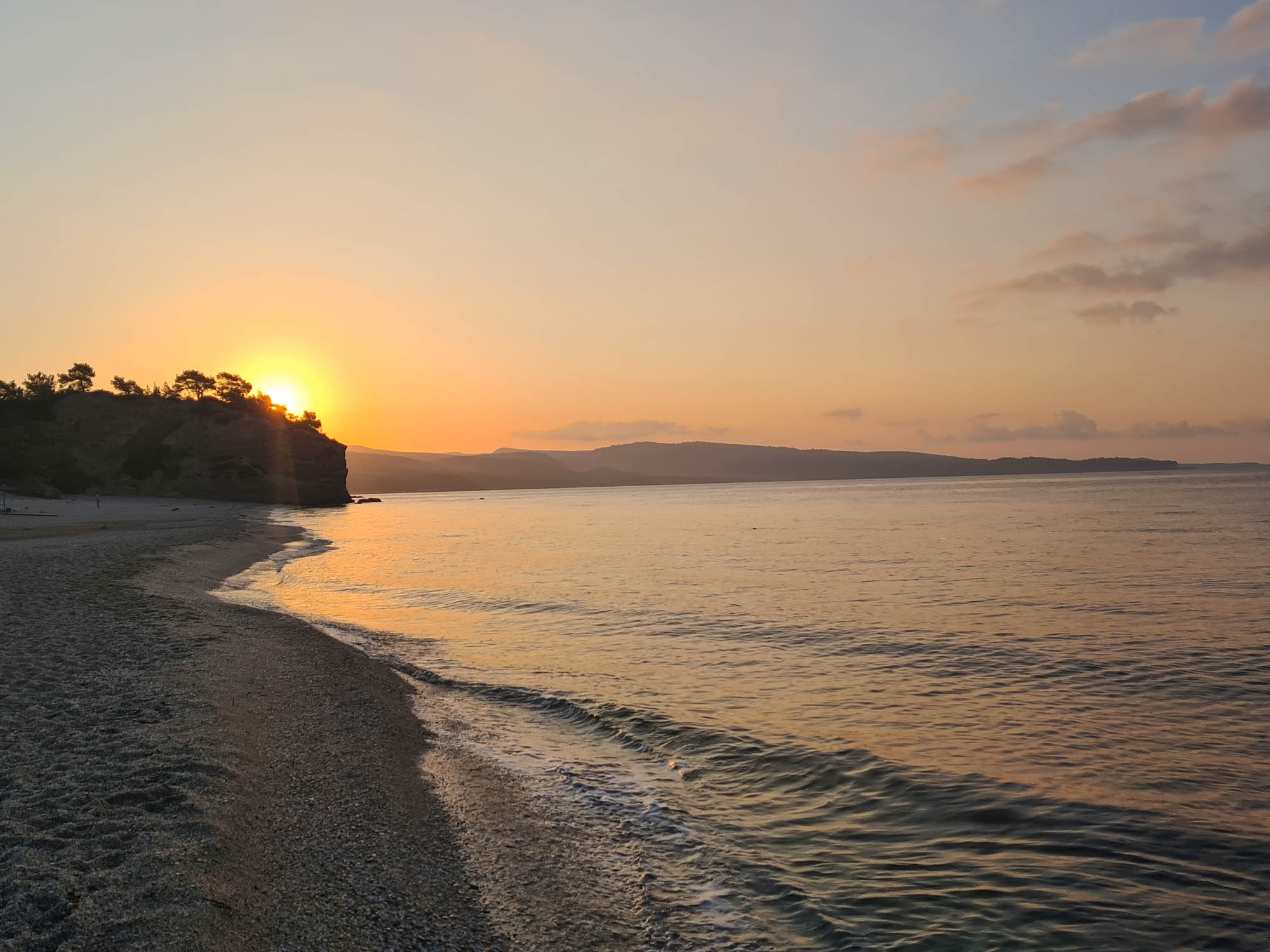 zachód słońca nad morzem obserwowany z plaży, piękne widoki grecji