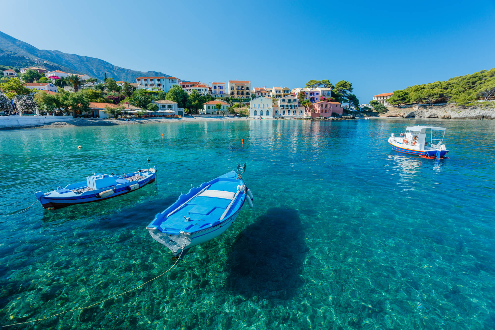 łódeczki na idealnie krystalicznej wodzie, idylliczne greckie miasteczko w tle, kefalonia