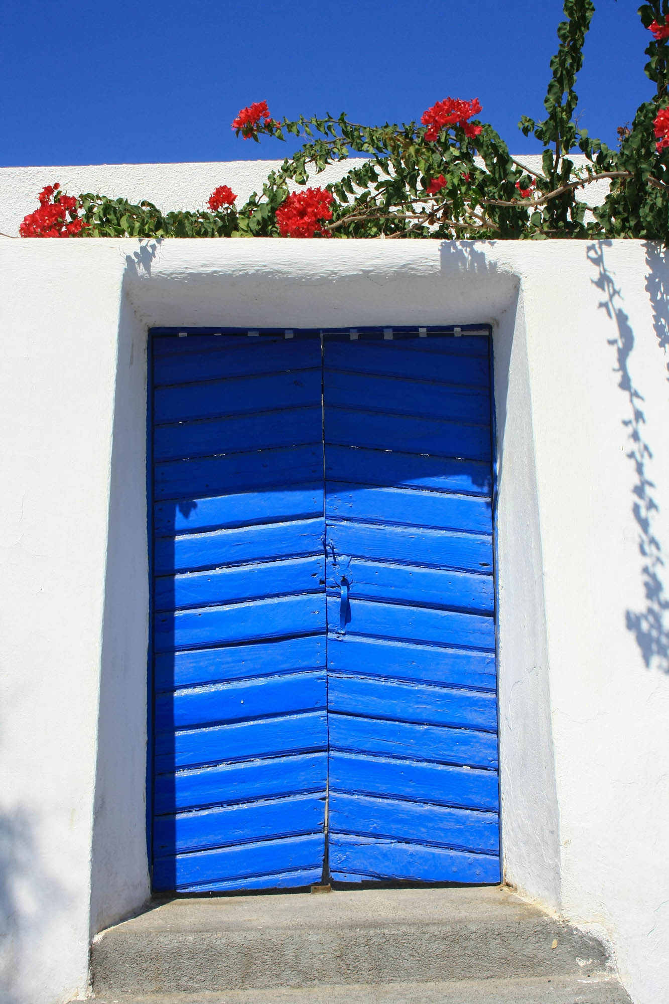 niebieskie drzwi prowadzące do białego domu, santorini
