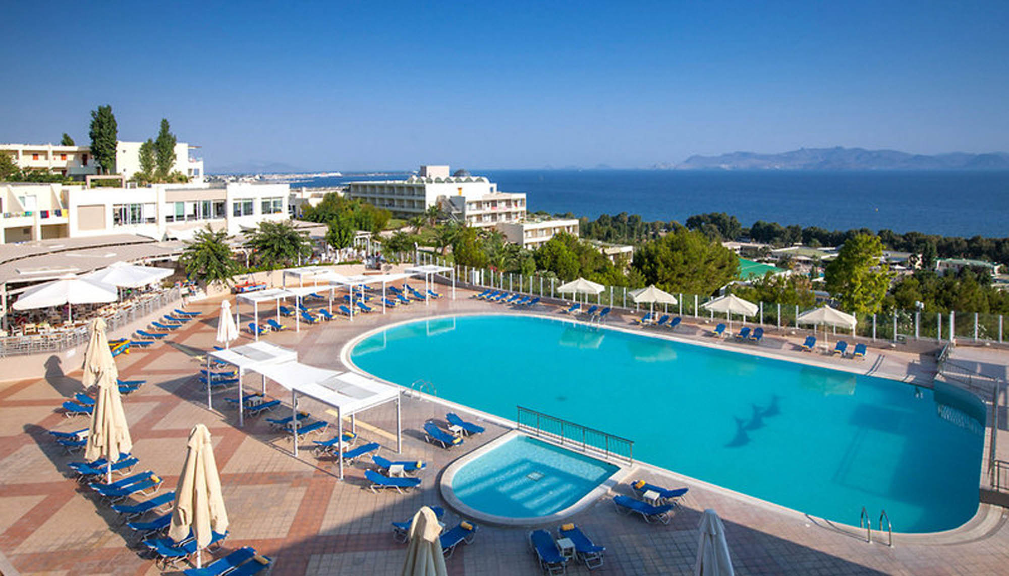 widok na basen w hotelu w grecji, w tle morze oraz niebo