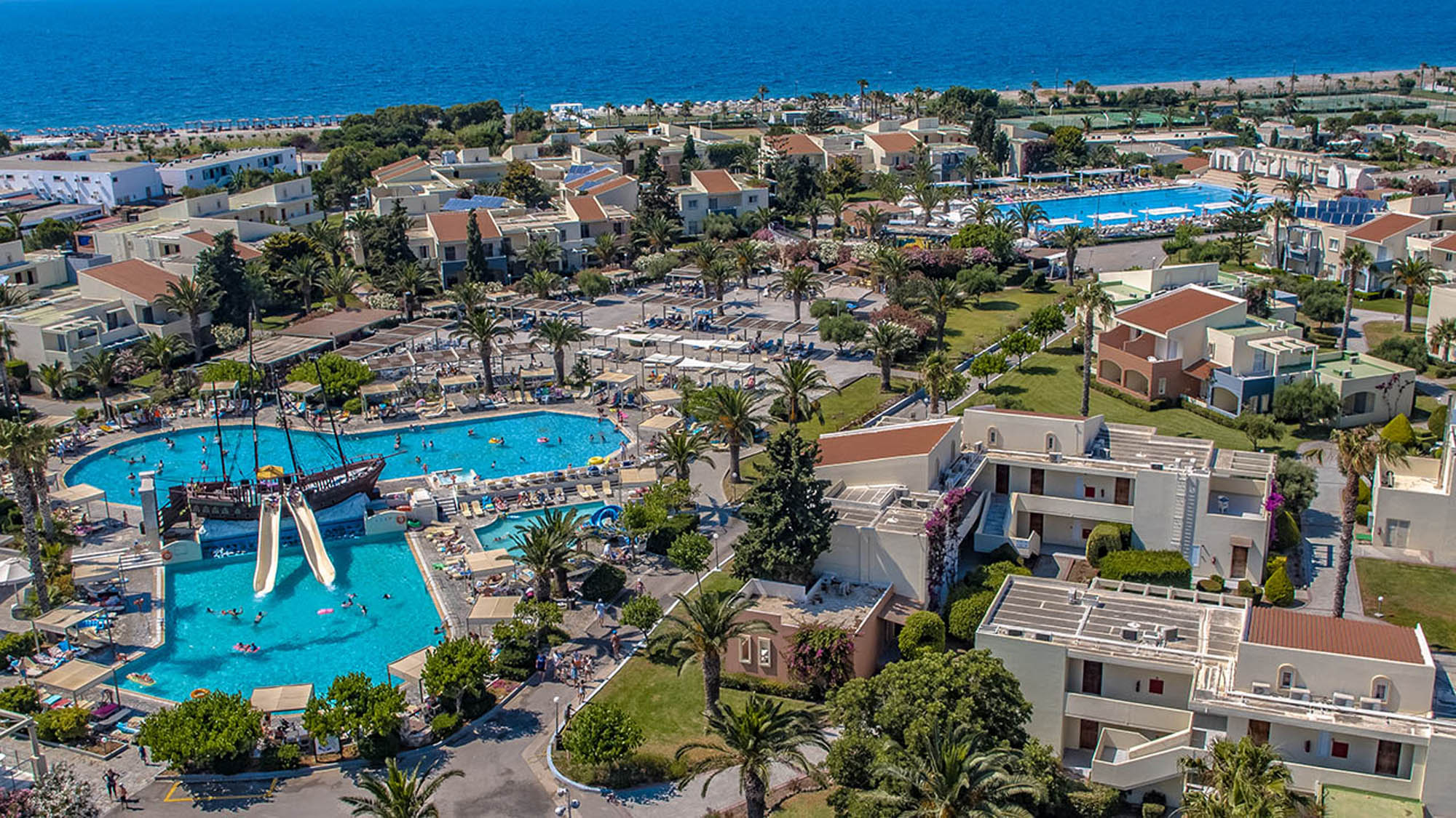 widok z lotu ptaka na hotel z basenami i aquaparkiem, w tle morze