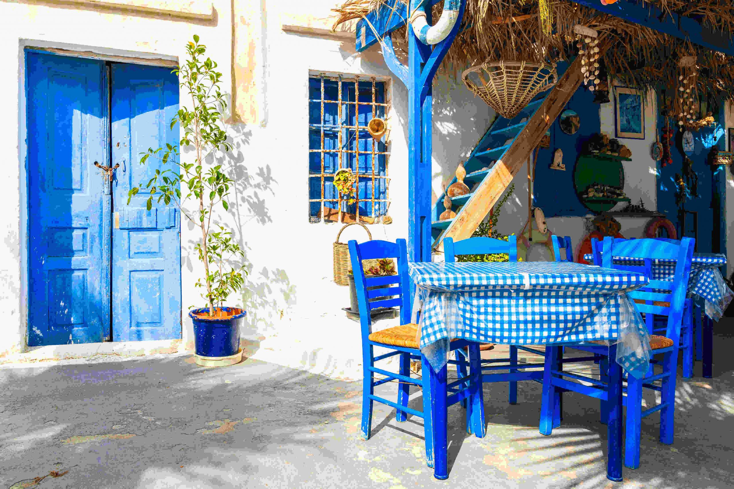 typowa grecka kawiarnia z niebieskimi stolikami