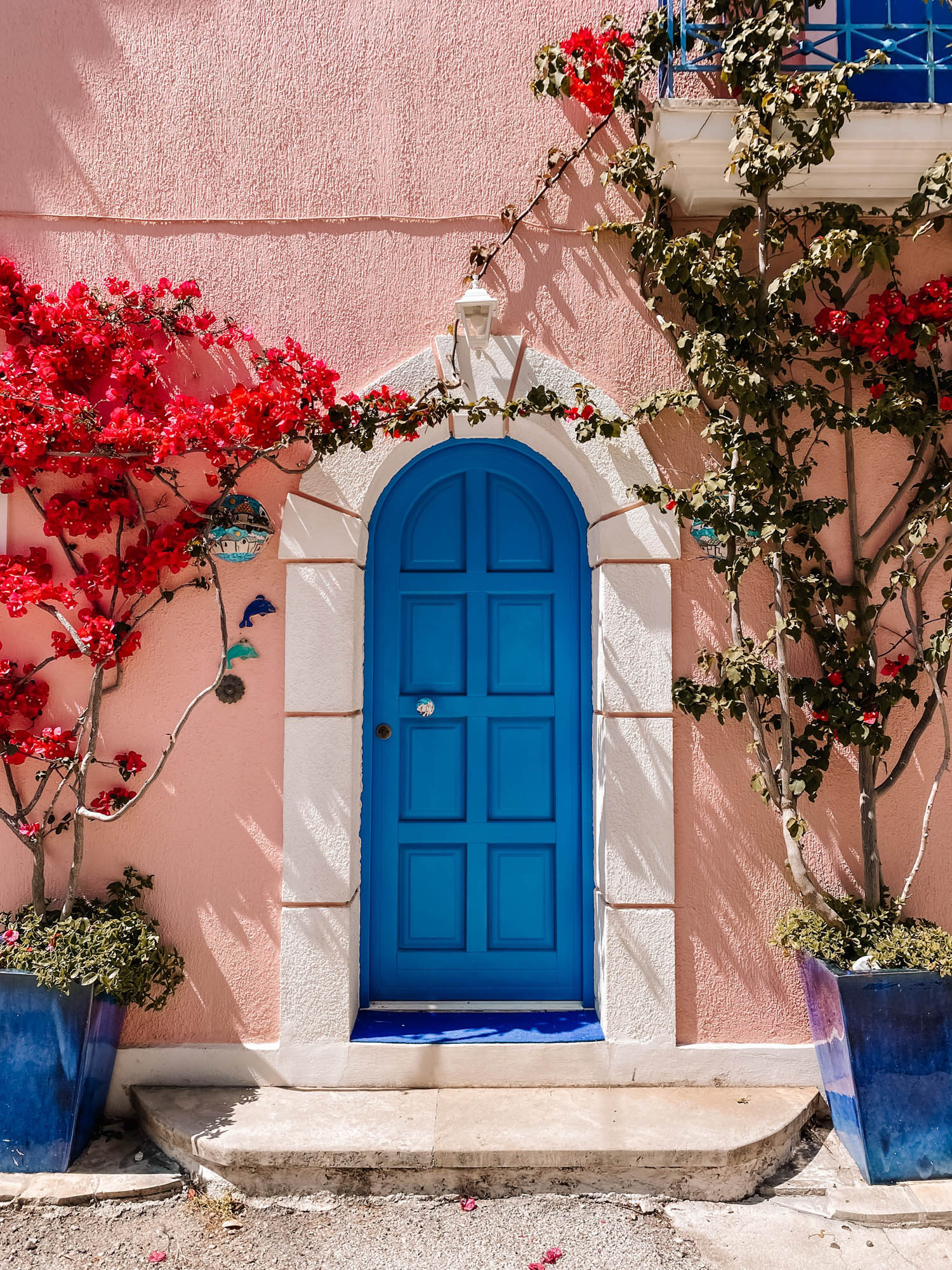 niebieskie drzwi i typowe kolorowe kwiaty na kefaloni, miasteczko asos