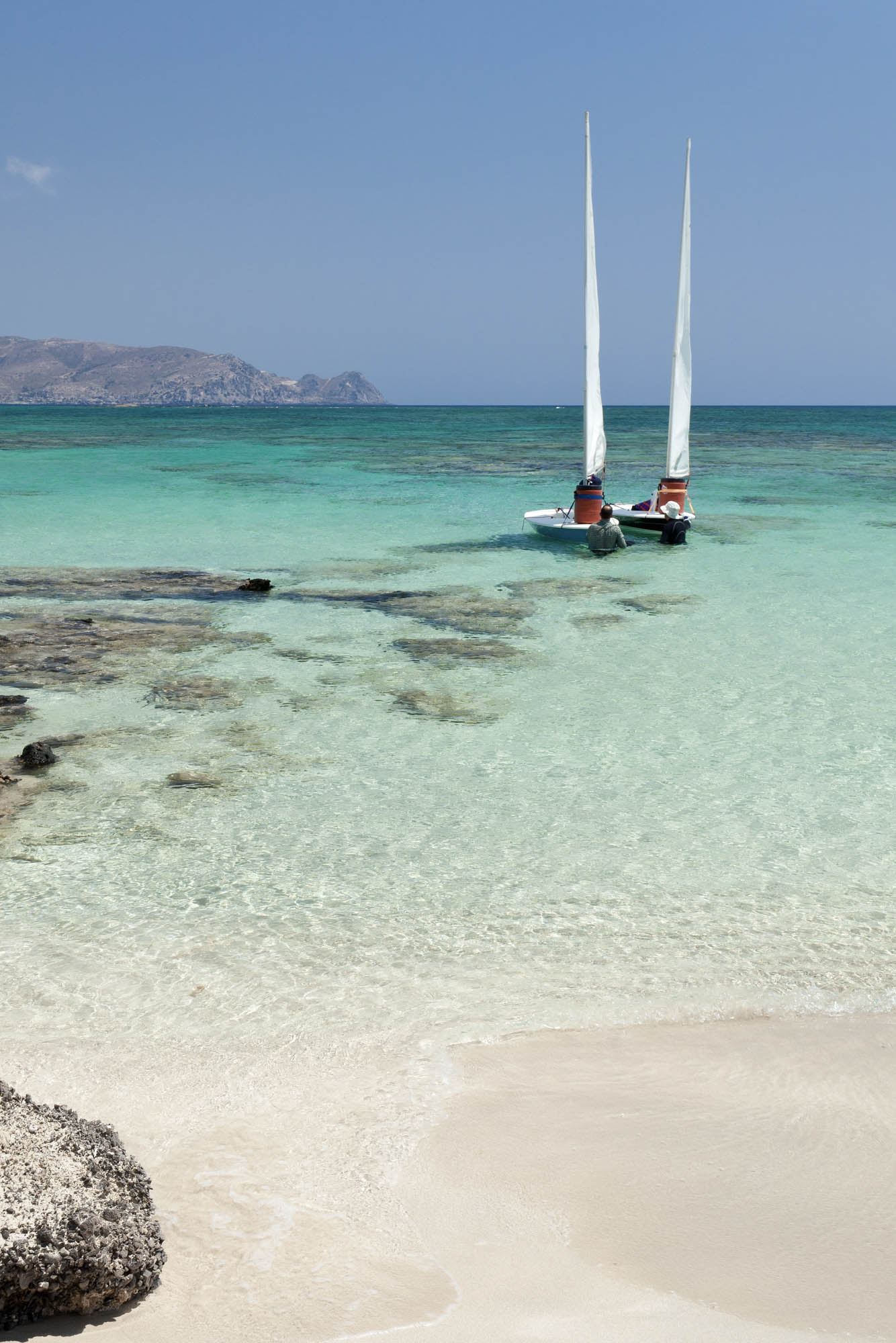 wspaniała plaża elafonisi, różowy piasek, lazurowa woda i jachty w tle
