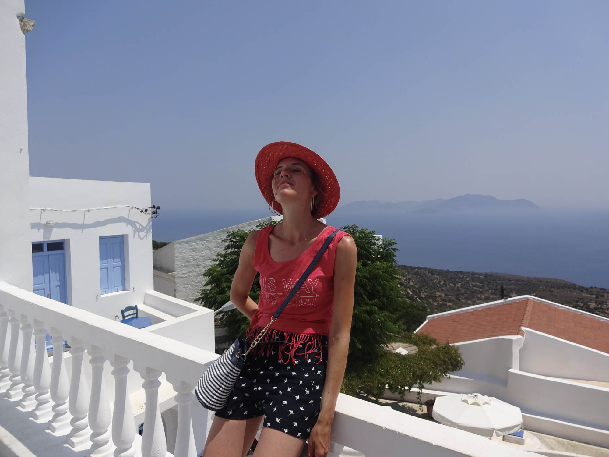dziewczyna stojąca na balkonie, w tle morze, grecja