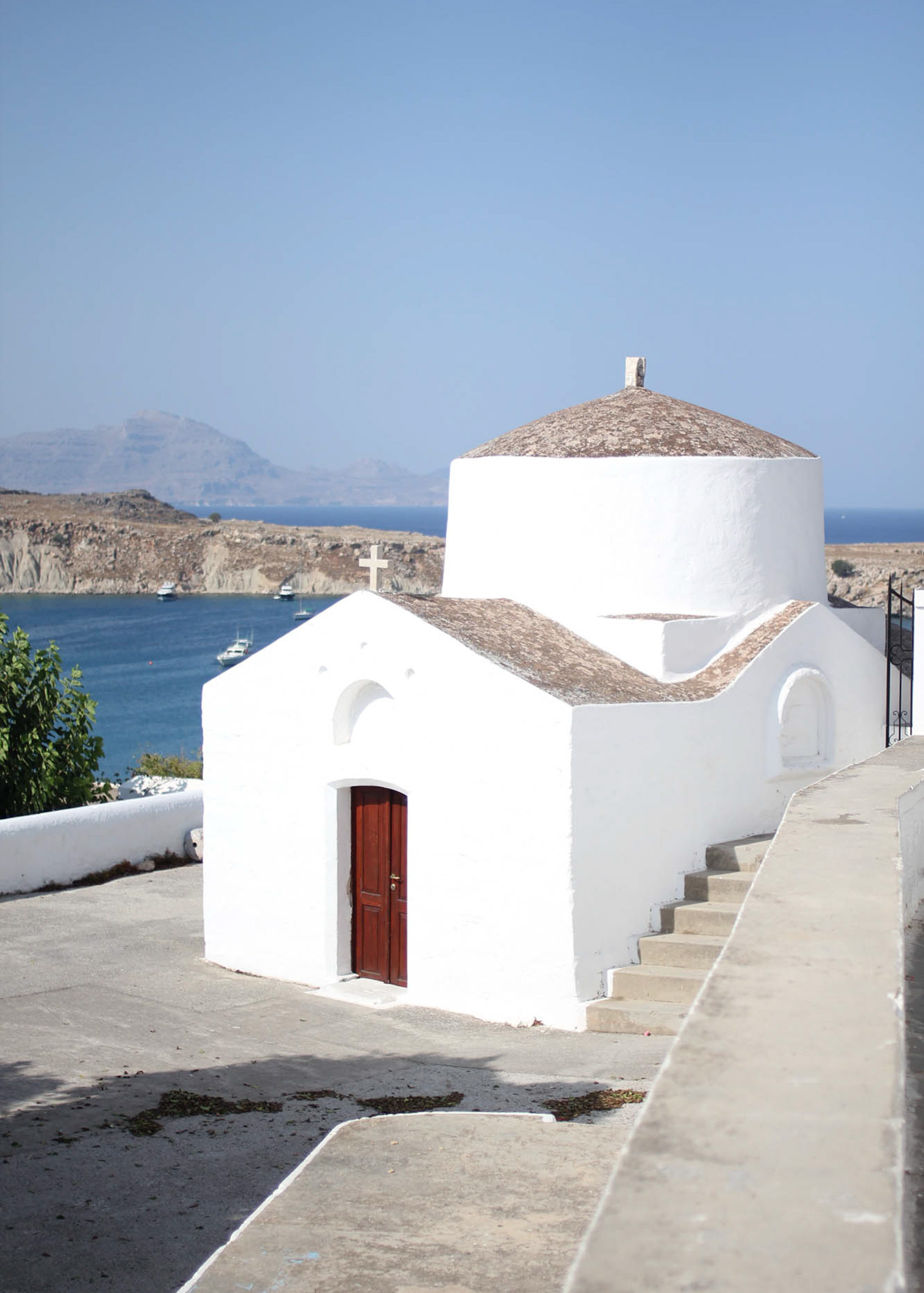kapliczka w mieście lindos, biała cerkiew w widokiem na morze