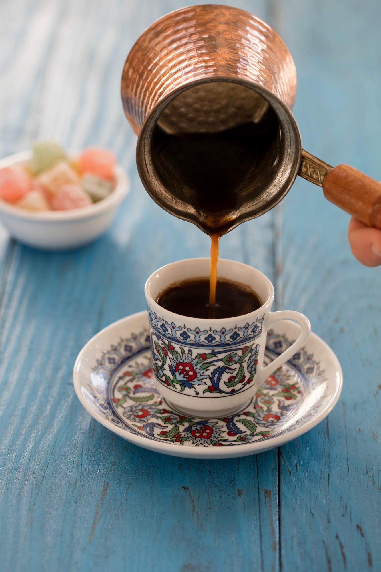 kawa nalewana z tygielka do kolorowej filiżanki