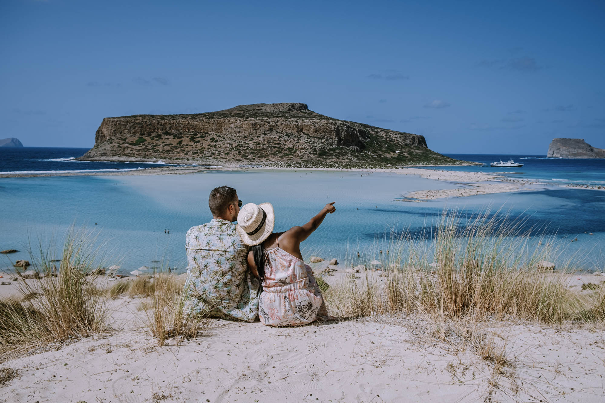 plaża balos, romantyczne ujęcie z parą siedzącą na piasku, przytuleni patrzą na morze