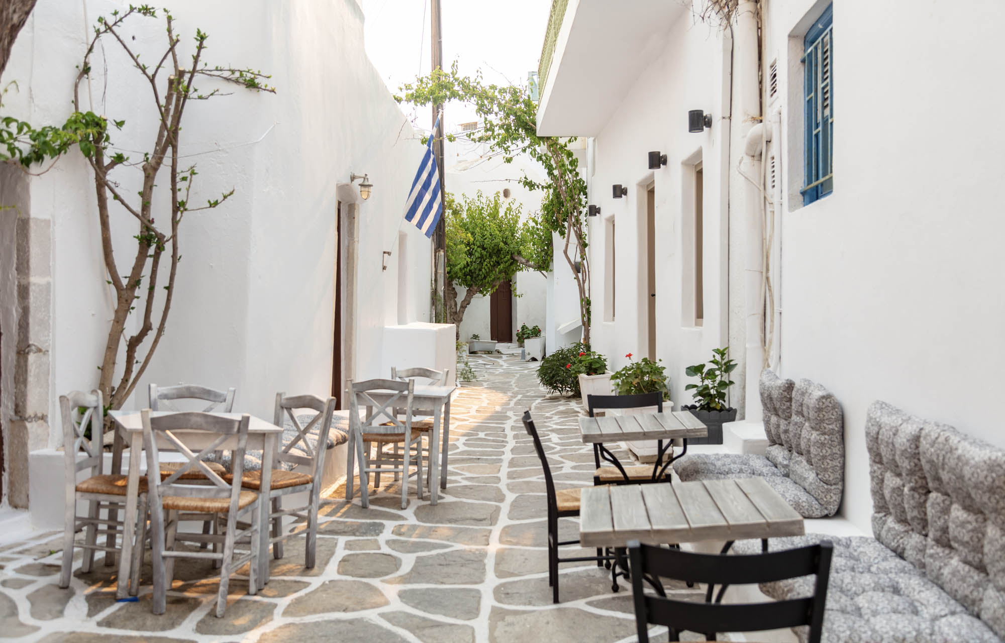 typowa grecka uliczka z kawiarnianymi stolikami
