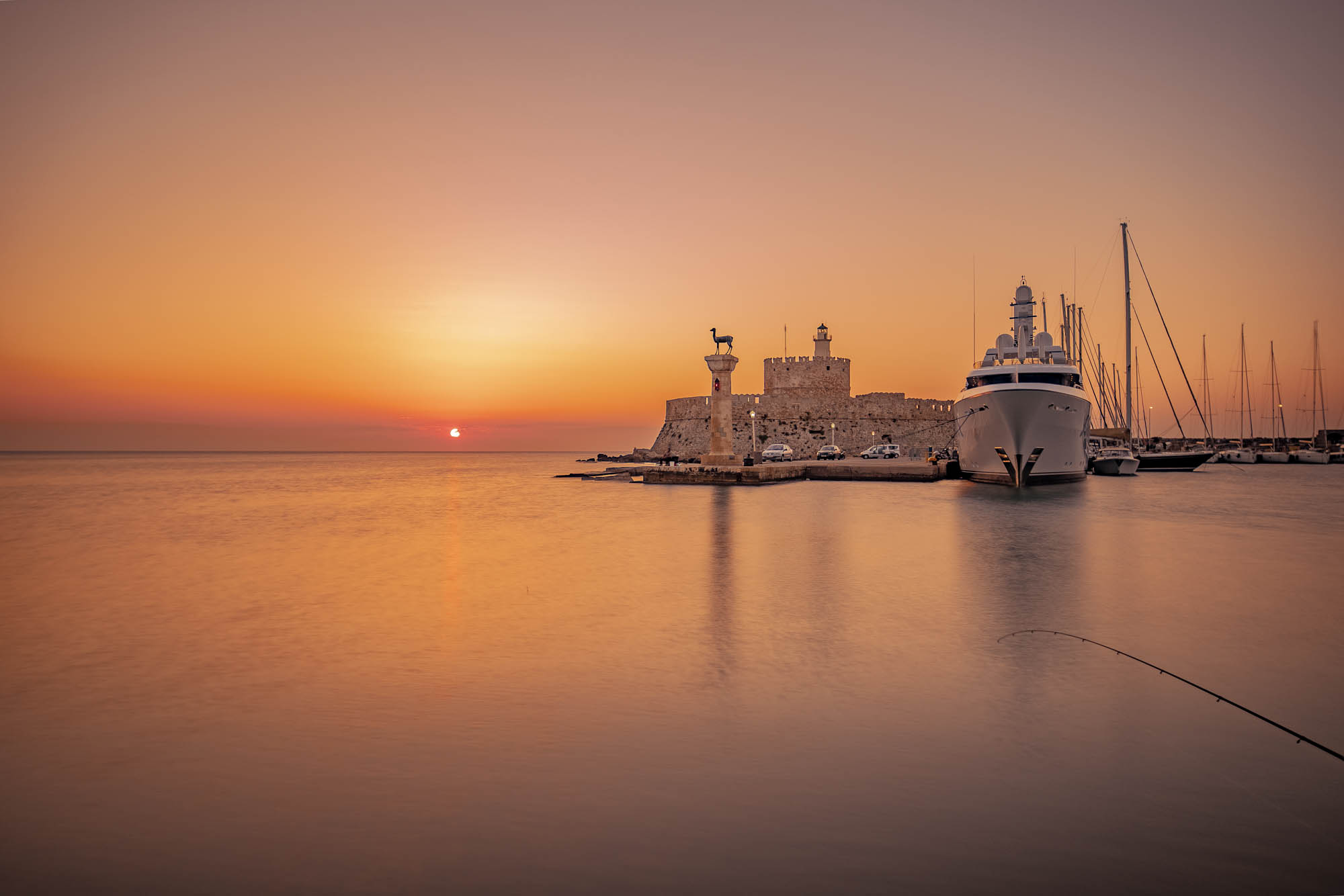port Mandraki w świetle słońca, pomarańczowa poświata, panorama