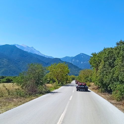 widok na góry olimp, droga a na niej samochód terenowy, panorama