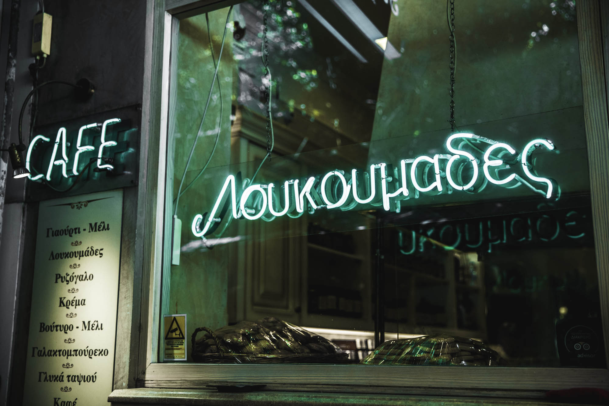 grecka kawiarnia z neonem informującym o kawie i pączkach