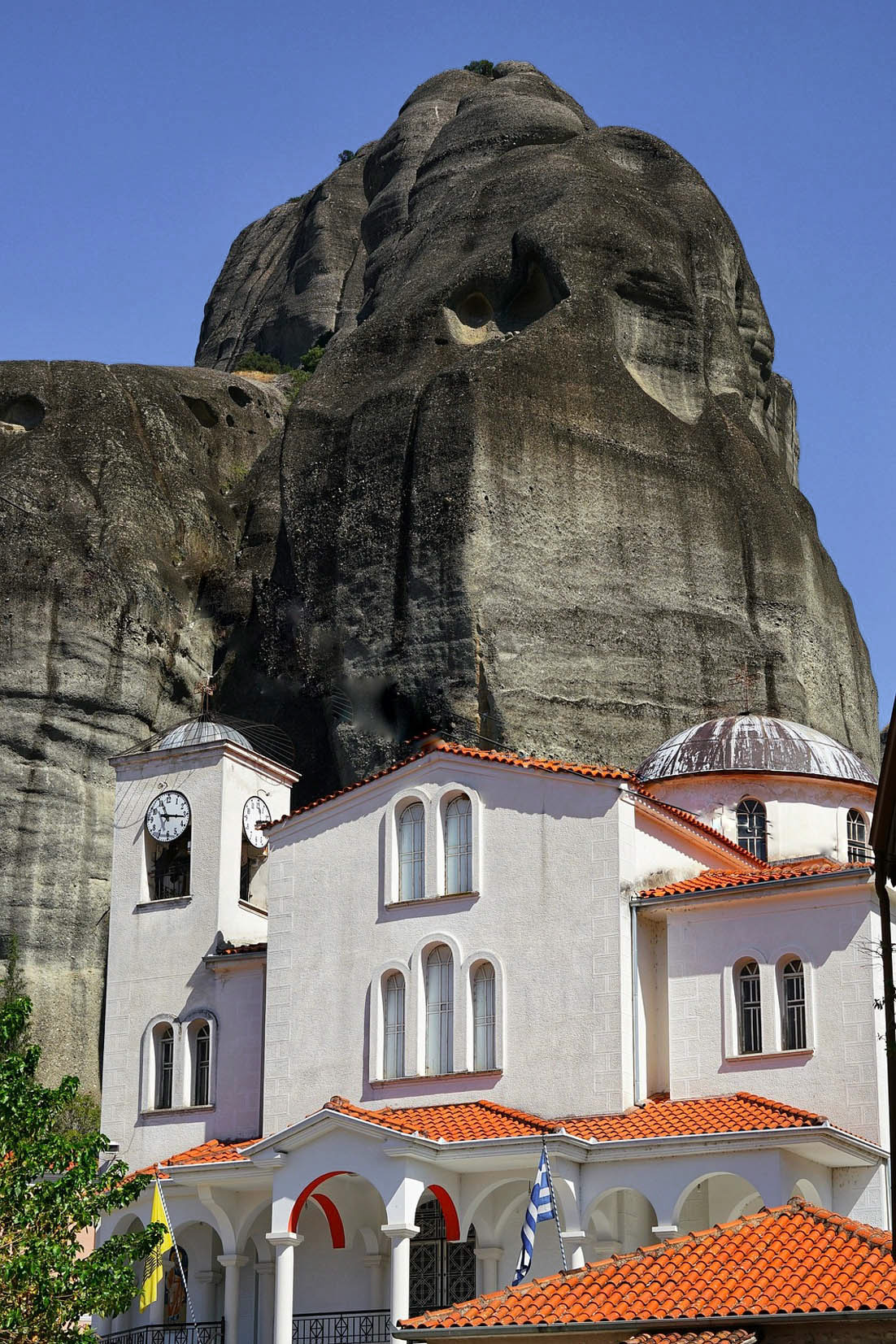 zdjęcie z dołu, cerkiew, a w tle skały, teren greckich meteor