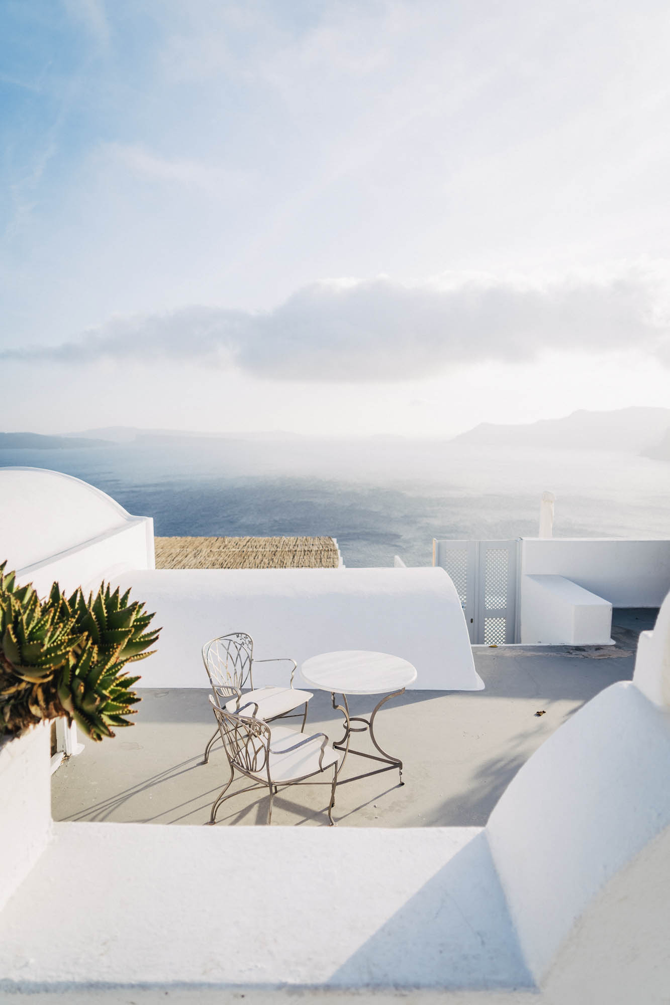 grecki widok białymi budynkami i pięknym stolikiem, zachęca do wypicia kawy