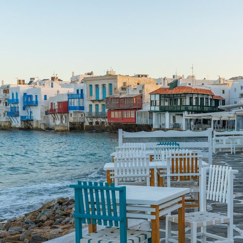 grecka tawerna na brzegu morza, kolorowe budynki i krzesełka