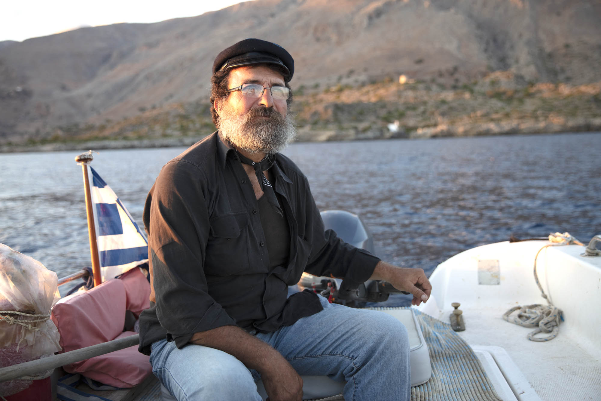 rybak siedzący na swojej łódce, gdzieś w grecji