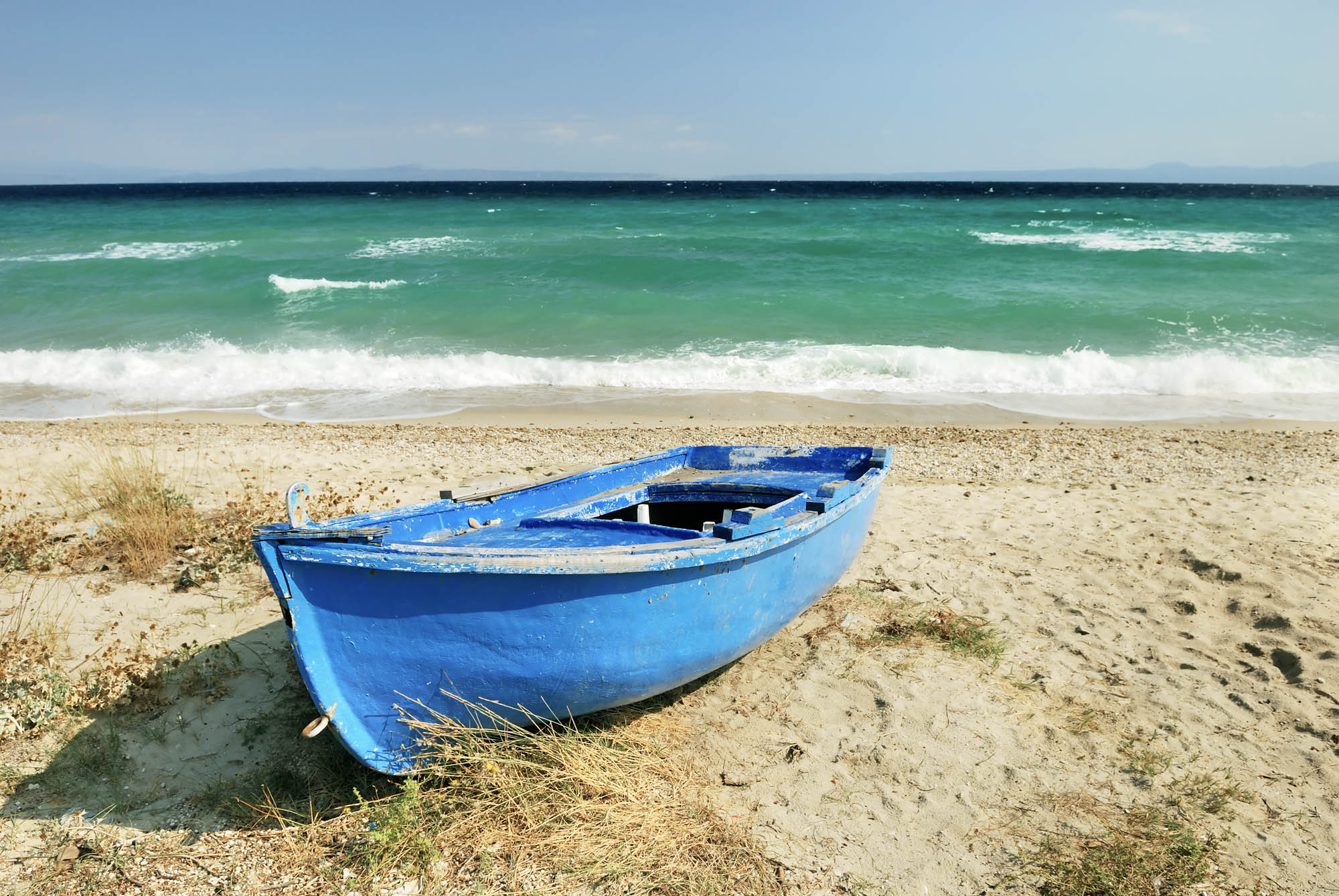 łódka i niebieskie morze w tle, idealny piasek na plaży, panorama, detal