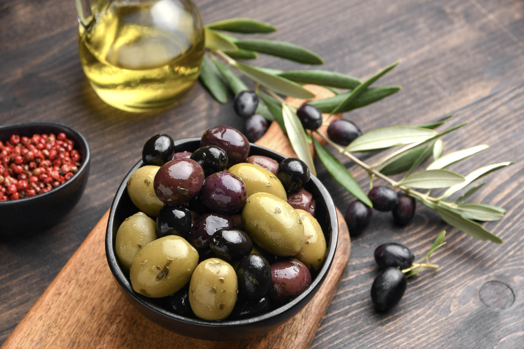 miks oliwek czarnych, brązowych i zielonych podanych na talerzyku, pyszne przystawki