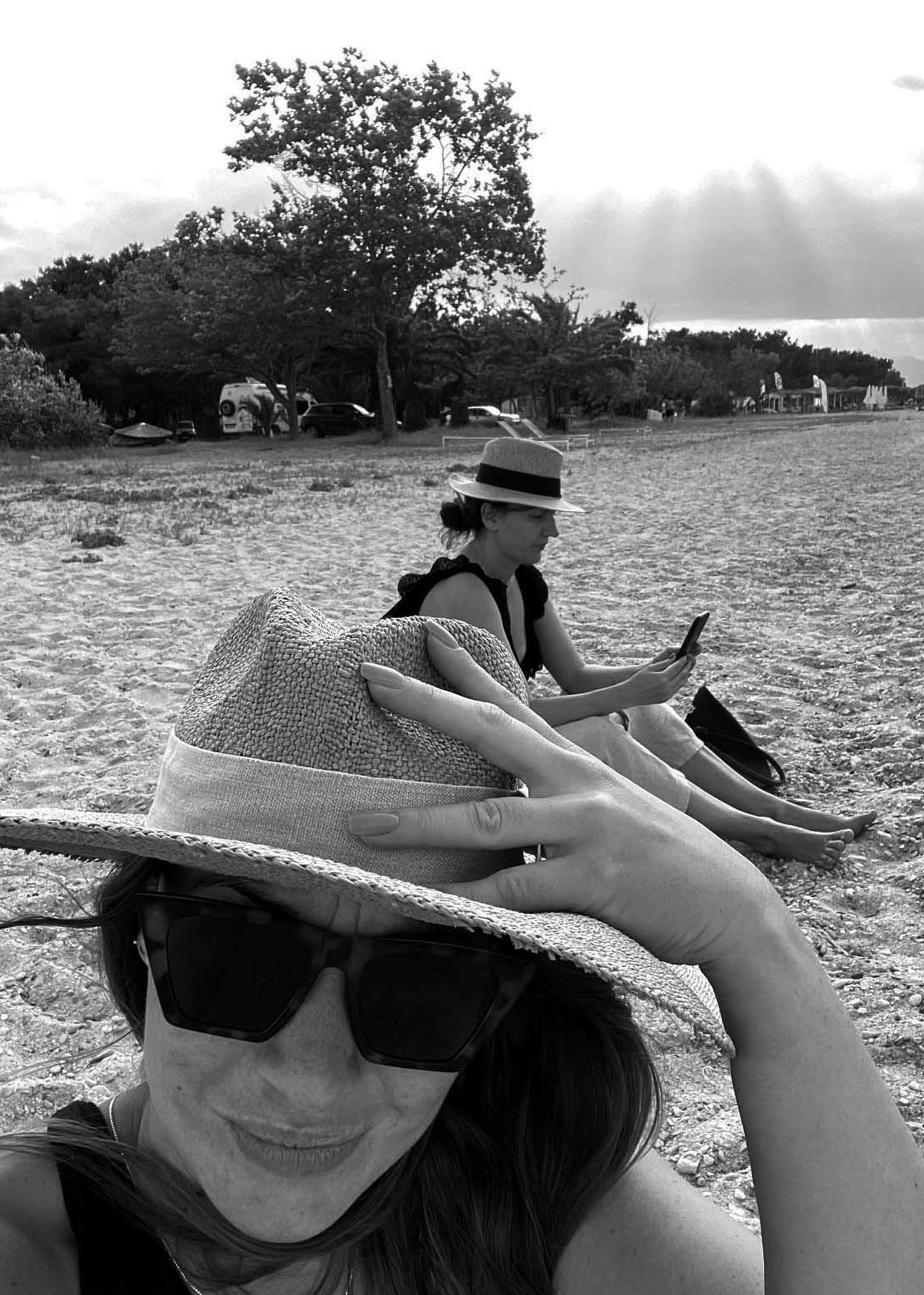 czarno-białe zdjęcie, dwie dziewczyny siedzące na plaży