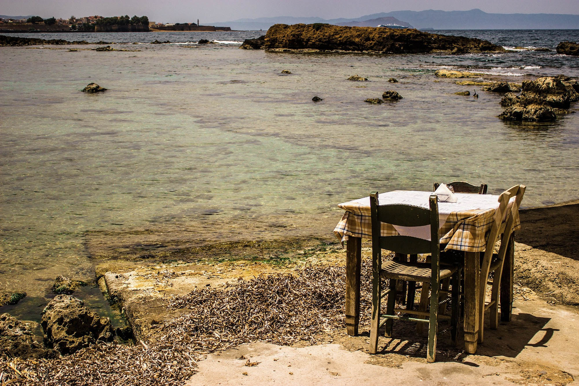 stolik na plaży w mieście chania, turkusowa woda i ładna panorama