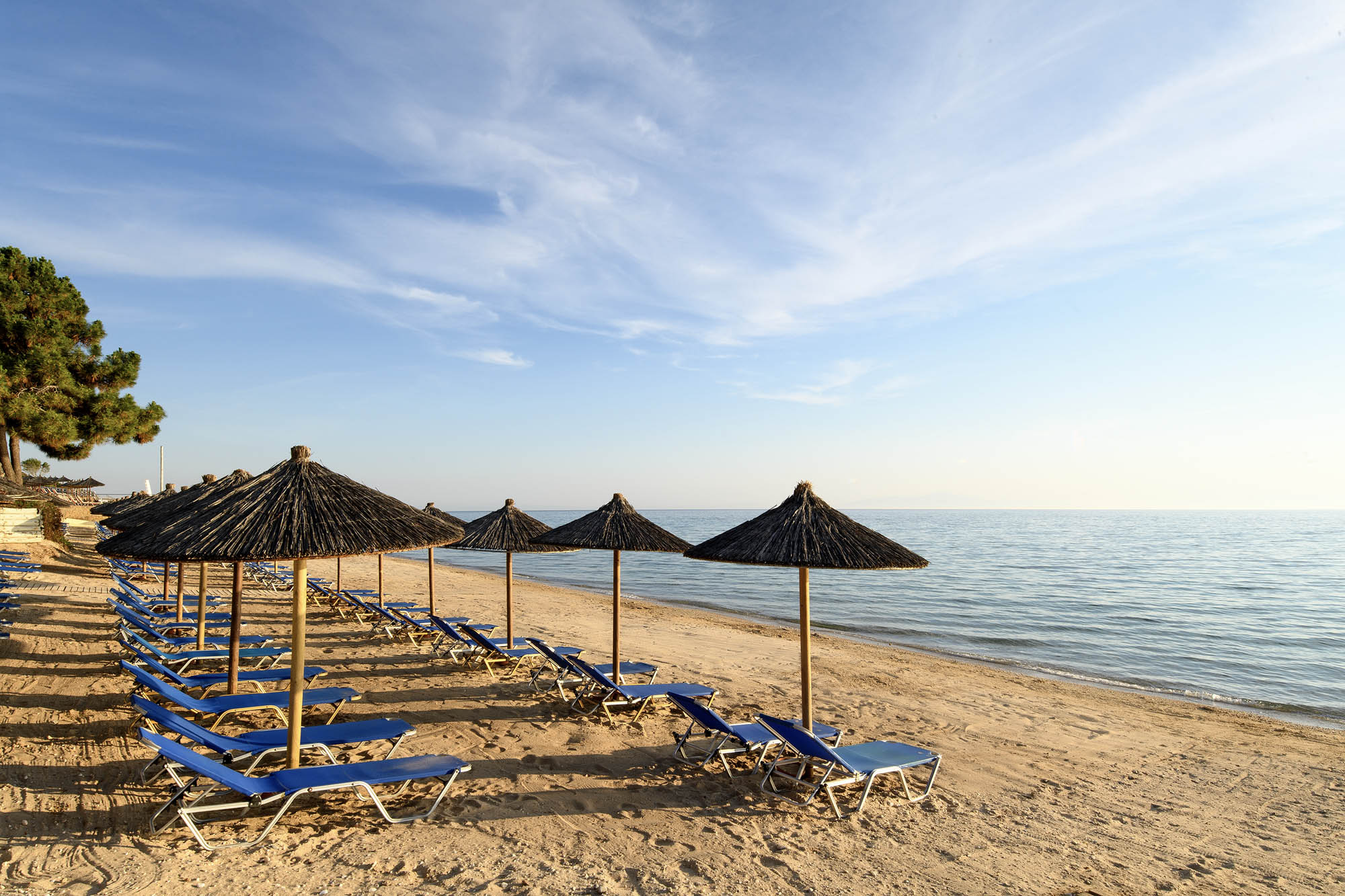 plaża przy hotelu na jednej z greckich wysp, detal,. parasolki,. piasek i morze