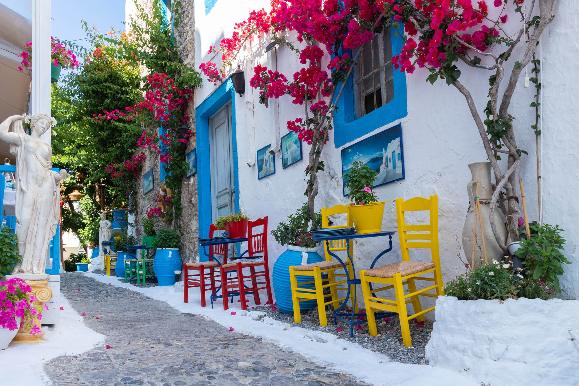 urokliwa ulica w mieście kos, piękna tawerna z kolorowymi krzesłami, detal
