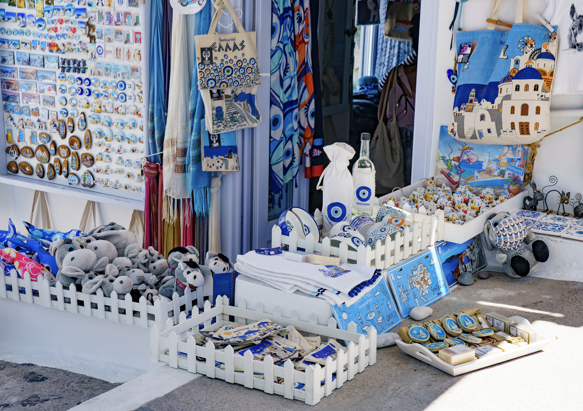sklep z pamiątkami w grecji, wszędzie królują niebieskobiałe barwy i symbol niebieskiego oka