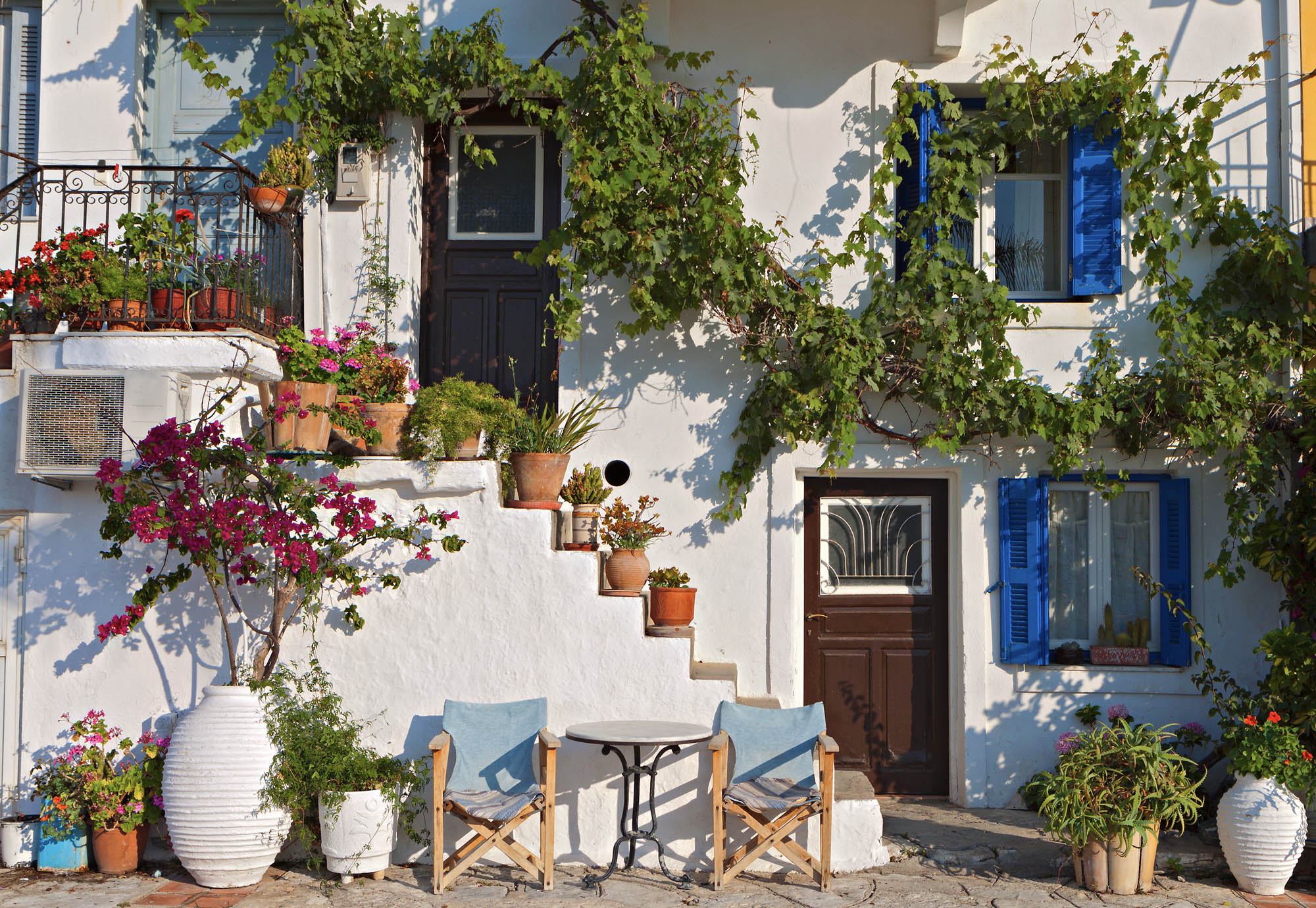 dom w mieście Parga, piękny tradycyjny dom grecki, białe ściany i niebieskie okienice, oraz masa kwiatów