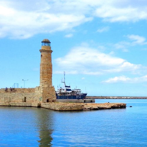 port wenecki w mieście Rethymno, latarnia morska i w tle starek, morze i niebo