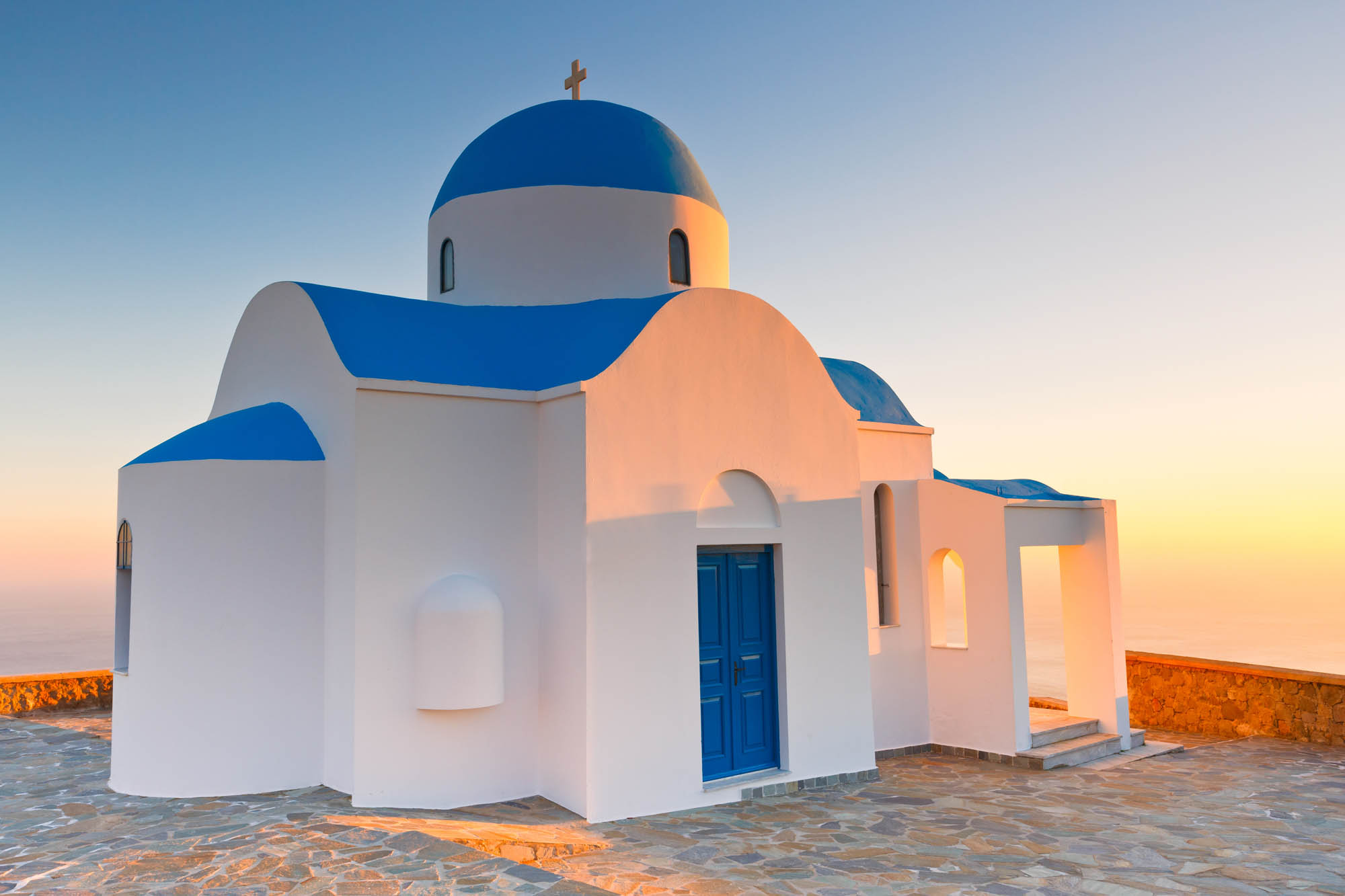 cerkiew na wzniesieniu, wyspa nisyros, cerkiew w świetle zachodzącego słońca, niebiesko biała, grecka