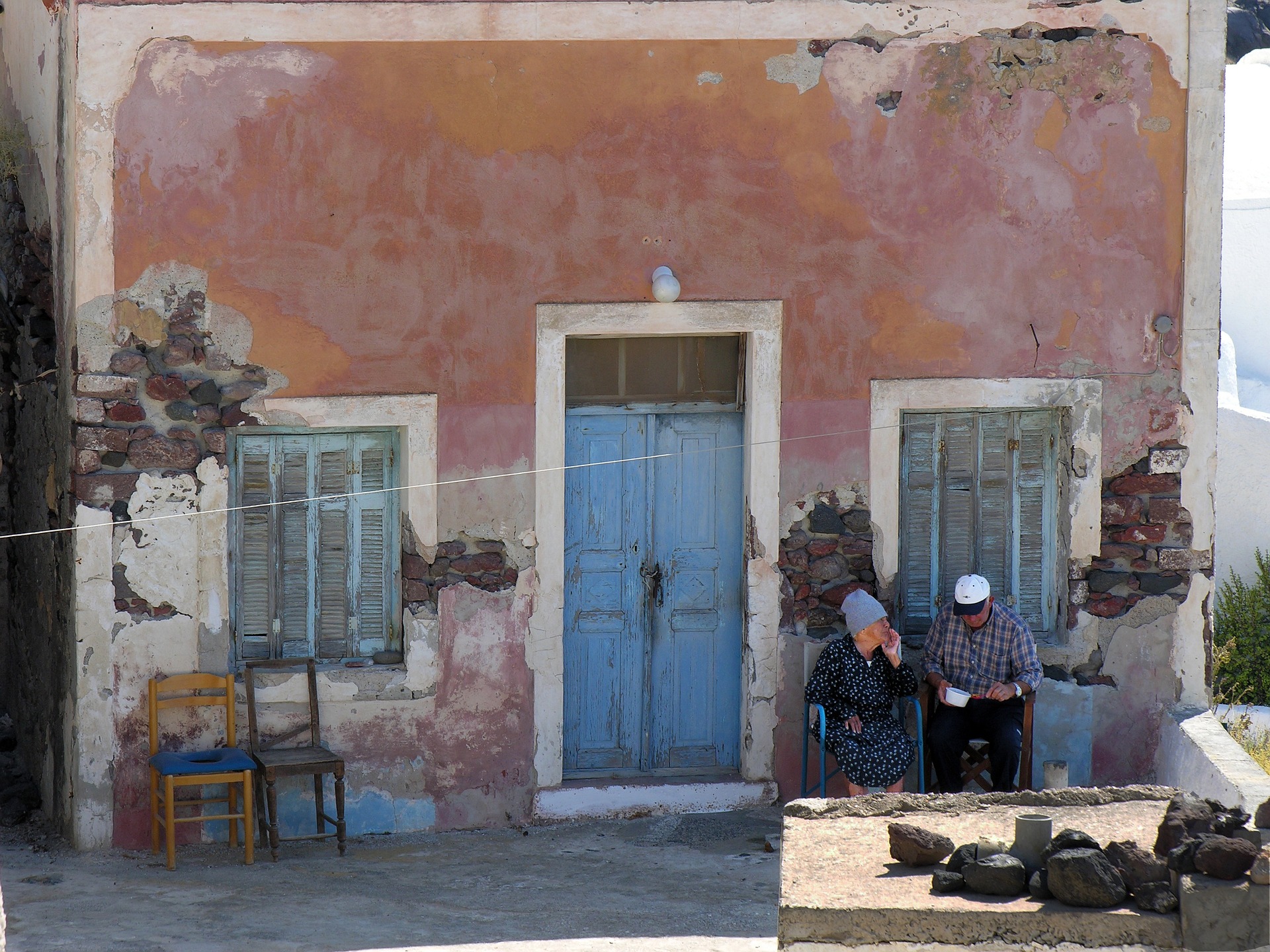 grecja, staruszkowie siedzą przed domem