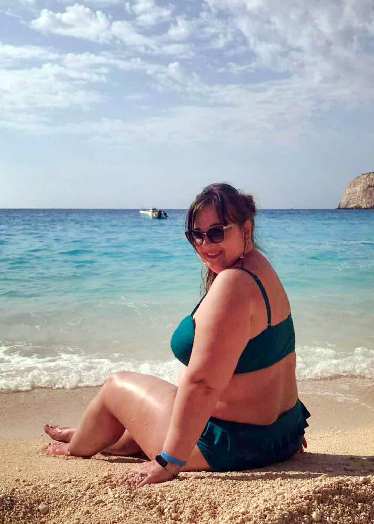 dziewczyna na plaży zakynthos, dziewczyna w kostiumie kąpielowym siedzi na plaży