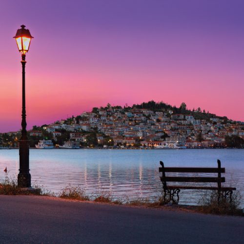 niezwykły, różowy zachód słońca, piękny widok na greckie wybrzeże, ławeczka i uliczna latarnia