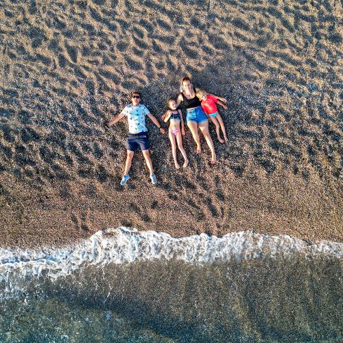 zdjęcie z drona, z góry, rodzina leży na piasku na plaży, rodos, plaża i morze