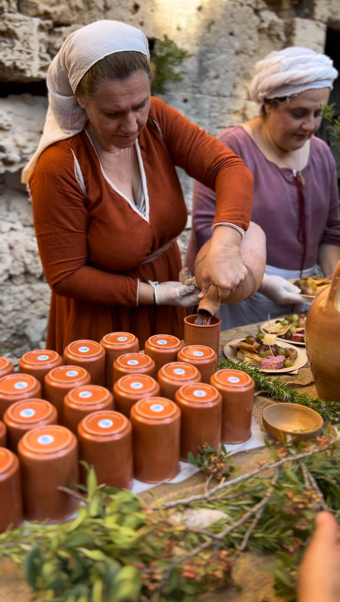 festiwal średniowieczny w mieście rodos, kobieta w stroju średniowiecznym sprzedaje przetwory, średniowieczny bazar, grecja