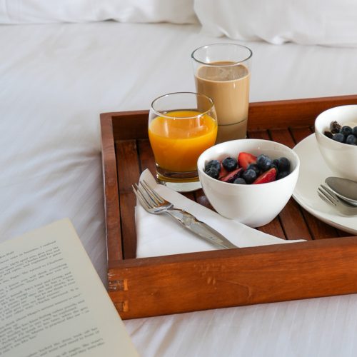 jedzenie i hotelowe łóżko, śniadanie na tacy