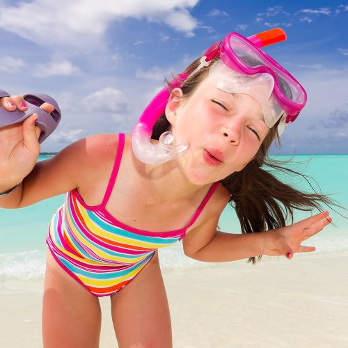 dziecko nad morzem, dziewczynka w kostiumie kąpielowym, śmieszne zdjecie dziecka