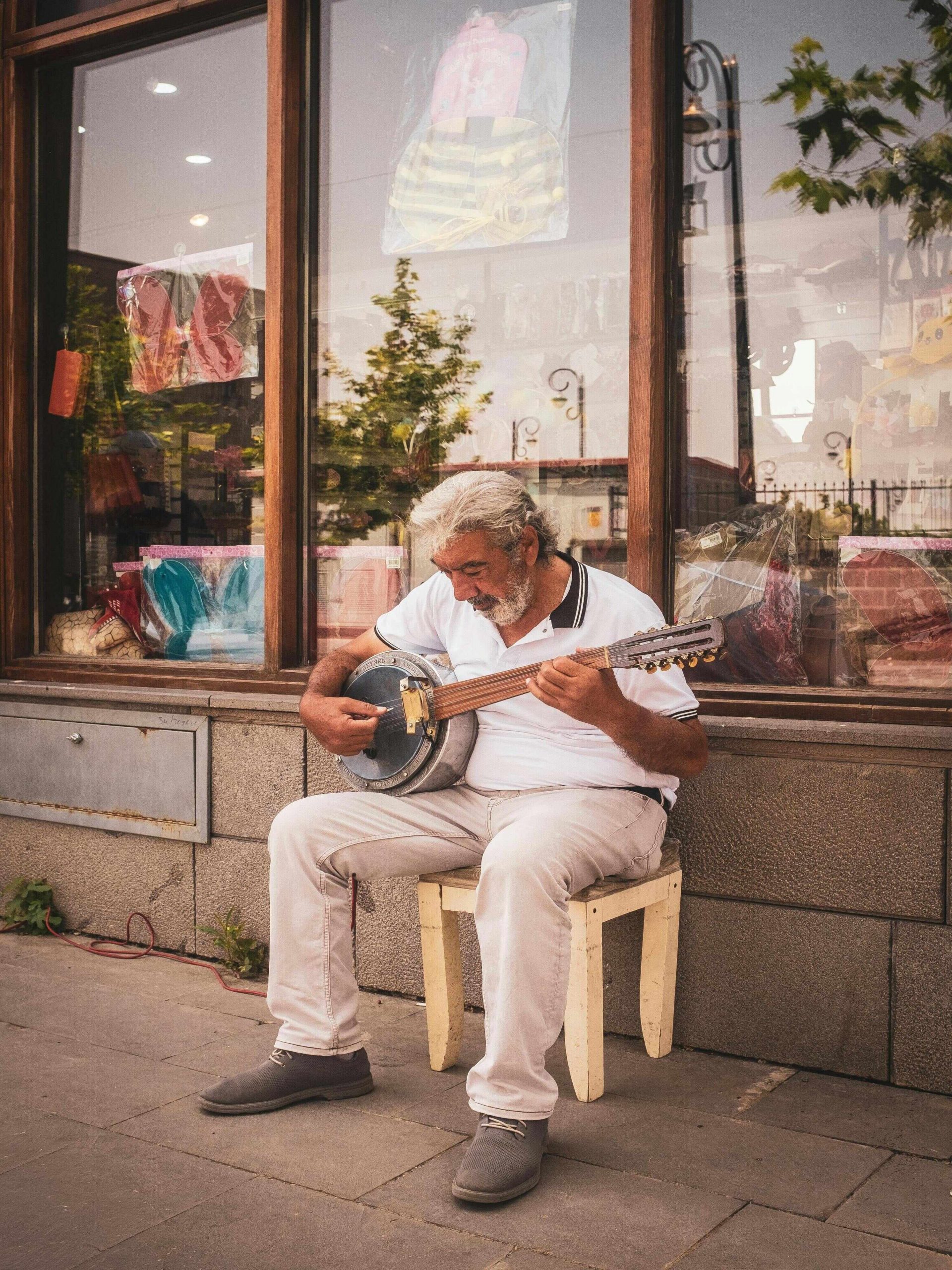 człowiek na ulicy, grający na bouzouki, typowy instrument