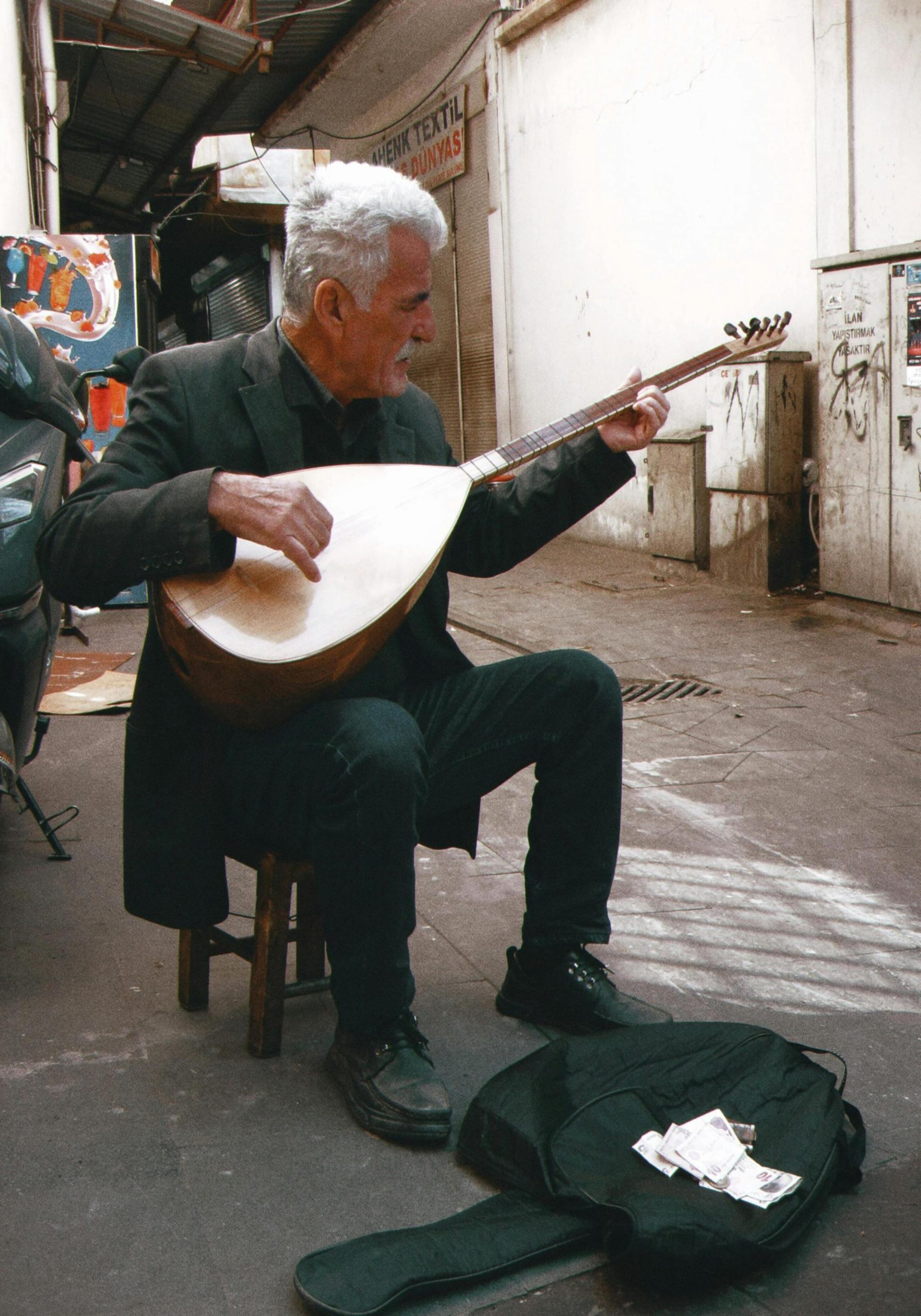 człowiek na ulicy, grający na bouzouki, typowy instrument