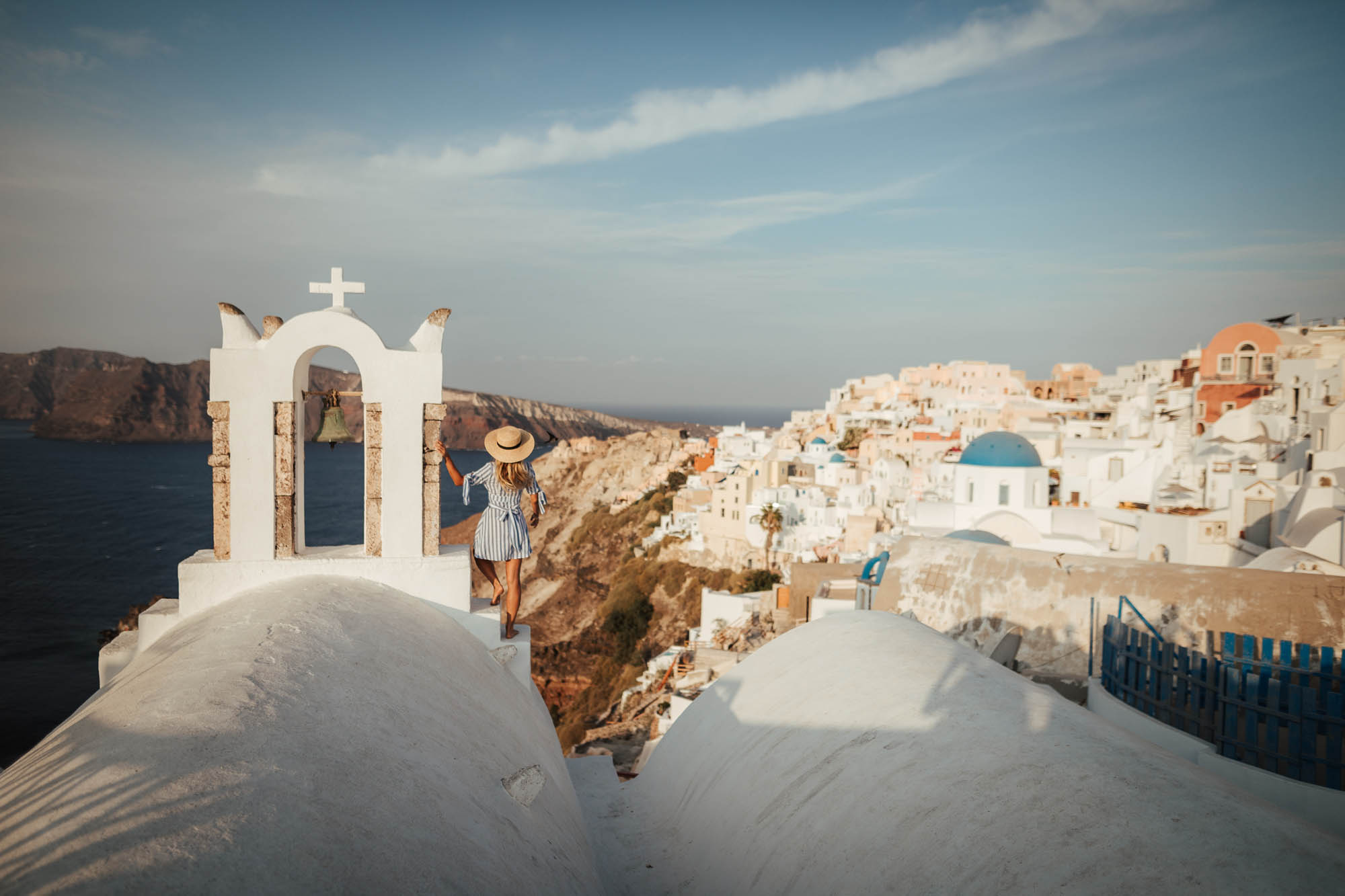widok na santorini, oia, kobnieta na dachu z widokiem na miasteczko, zachód słońca